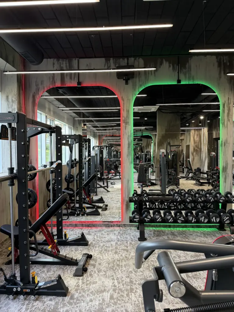 A The Gym Club gépterme piros és zöld LED-keretes boltíves tükrökkel, Smith-géppel és kézisúlyzó-állvánnyal
